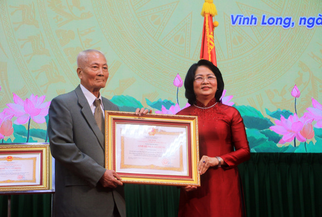 Phó Chủ tịch nước Đặng Thị Ngọc Thịnh trao danh hiệu Anh hùng Lao động thời kỳ đổi mới cho ông Ngô Ngọc Bỉnh. (Ảnh: Phạm Minh Tuấn/TTXVN) Vĩnh Long tổ chức Lễ đón nhận danh hiệu Anh hùng Lao động ảnh 1