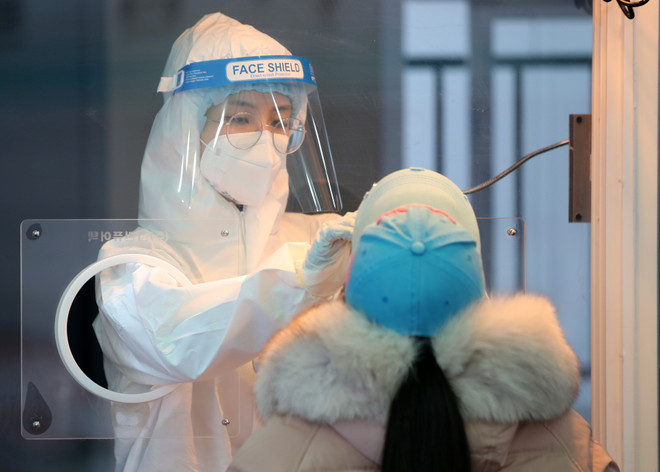 Nhân viên y tế lấy mẫu xét nghiệm COVID-19 cho người dân tại Seoul, Hàn Quốc. (Ảnh: Yonhap/ TTXVN) Dịch COVID-19 ngày 10/2: Hơn 79,4 triệu bệnh nhân đã được chữa khỏi ảnh 1