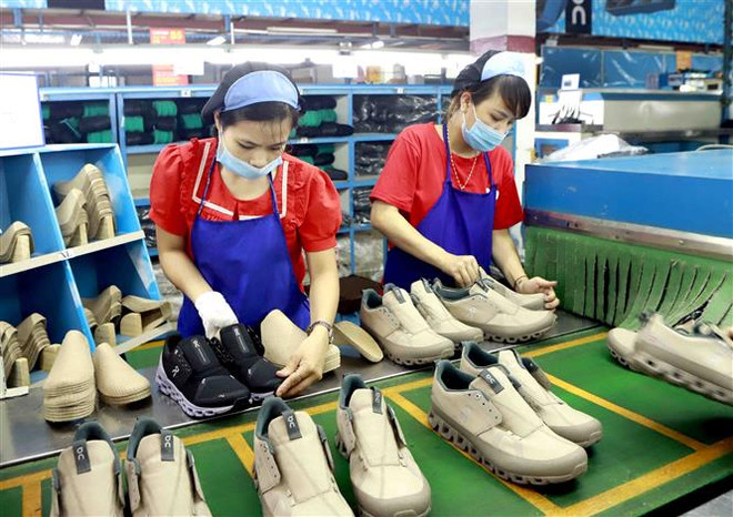 Công ty giầy Phúc Yên (Vĩnh Phúc) phấn đấu năm 2021 sản xuất 1.2 triệu đôi giày phục vụ thị trường trong nước và xuất khẩu. (Ảnh: TTXVN) Fitch Solutions dự báo kinh tế Việt Nam tăng trưởng cao 10 năm tới ảnh 1