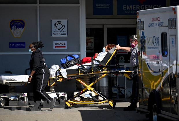 Nhân viên y tế chuyển bệnh nhân COVID-19 tới trung tâm y tế tại New York, Mỹ. (Ảnh: AFP/TTXVN) Nước Mỹ vẫn đứng đầu khu vực và thế giới về số ca nhiễm và tử vong ảnh 1