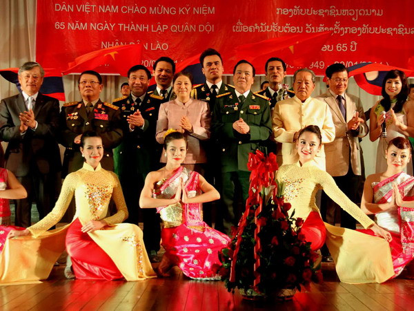 Lãnh đạo Lào và Đại sứ Nguyễn Mạnh Hùng tặng hoa chúc mừng các nghệ sỹ. (Ảnh: Hoàng Chương/Vietnam+) Nhà hát Ca múa nhạc Quân đội biểu diễn tại Lào ảnh 1