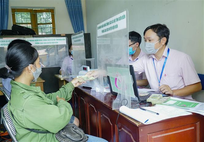 Cán bộ Ngân hàng chính sách xã hội giao dịch ở xã Thanh Luông, huyện Điện Biên. (Ảnh: Xuân Tư/TTXVN) Nghị quyết về chính sách tài khóa, tiền tệ hỗ trợ phục hồi kinh tế ảnh 1