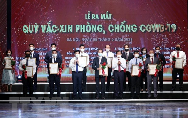 Đại diện các tập đoàn, tổng công ty, doanh nghiệp trao ủng hộ Quỹ vaccine phòng COVID-19. (Ảnh: Dương Giang/TTXVN) Tháo gỡ vướng mắc xếp loại DNNN đóng góp, ủng hộ phòng chống dịch ảnh 1