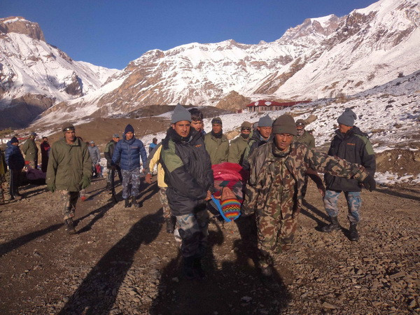 Lực lượng cứu hộ Nepal chuyển thi thể nạn nhân sau vụ lở tuyết tại Mustang ngày 15/10. (Nguồn: THX/TTXVN) Xác minh thông tin có người Việt mất tích trong vụ lở tuyết ở Nepal ảnh 1