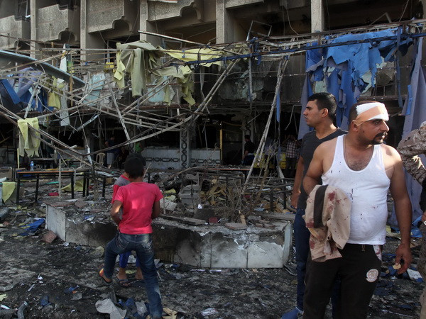 Hiện trường một vụ đánh bom tại Baghdad ngày 22/10. (Nguồn: AFP/TTXVN) Iraq: Đánh bom liều chết gần Baghdad, gần 90 người thương vong ảnh 1