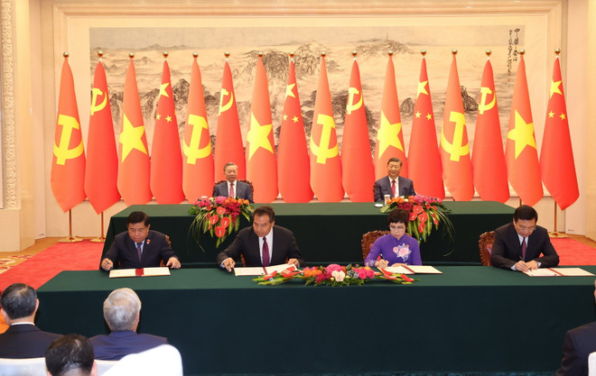 Lễ ký Thỏa thuận hợp tác nghiệp vụ giữa Thông tấn xã Việt Nam với Tân Hoa xã (bên phải) và hợp tác về đầu tư (bên trái) giữa hai nước. (Ảnh: Trí Dũng/TTXVN) ttxvn_ttxvn ky van kien.jpg