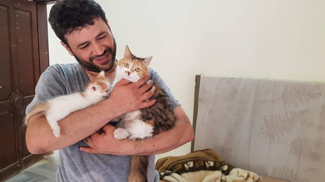 Mohammad Alaa Aljaleel bên những chú mèo mình chăm sóc. (Nguồn: Alaa and house of Cats Ernesto in Aleppo) Chuyện kỳ diệu về người đàn ông chăm sóc chó mèo bị bỏ rơi tại Syria ảnh 1