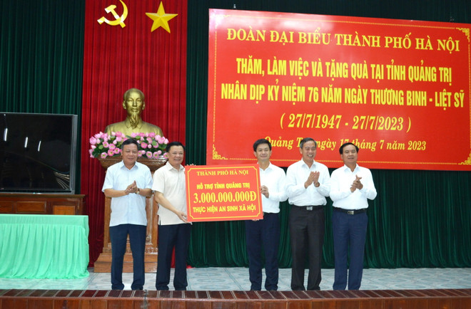 Bí thư Thành ủy Hà Nội Đinh Tiến Dũng trao tượng trưng 3 tỷ đồng hỗ trợ an sinh xã hội tỉnh Quảng Trị. (Ảnh: Nguyên Lý/TTXVN) Hà Nội và tỉnh Quảng Trị triển khai hợp tác trên nhiều lĩnh vực ảnh 2