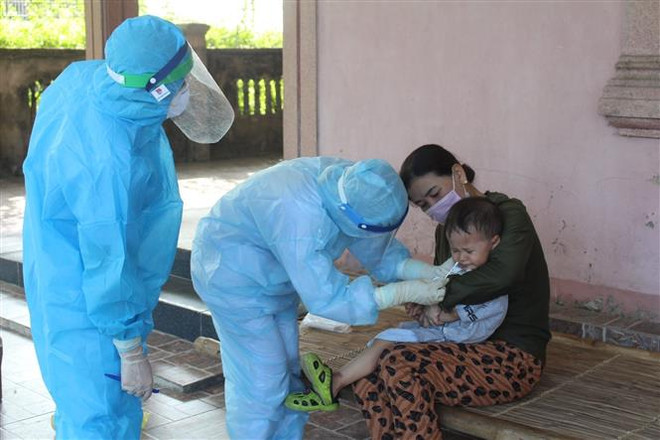 Lấy mẫu xét nghiệm COVID-19 đối với các hộ dân trong vùng phong tỏa ở thôn Trung Tiến, xã Việt Tiến (huyện Thạch Hà, Hà Tĩnh. (Ảnh: Hoàng Ngà/TTXVN) Người Việt tại Lào hướng về cuộc chiến chống COVID-19 tại quê hương ảnh 1
