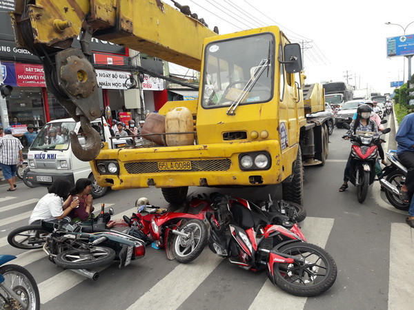 Dừng đèn đỏ, xe cẩu cuốn 4 xe máy vào gầm, 1 người tử vong ảnh 1