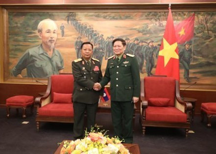 Đại tướng Chansamone Chanyalath, Ủy viên Bộ Chính trị, Phó Thủ tướng Chính phủ, Bộ trưởng Bộ Quốc phòng Lào gặp Đại tướng Ngô Xuân Lịch, nguyên Ủy viên Bộ Chính trị, nguyên Phó Bí thư Quân ủy Trung ương, nguyên Bộ trưởng Bộ Quốc phòng. (Ảnh: TTXVN phát) Tăng cường hợp tác quốc phòng hai nước Việt Nam-Lào ảnh 1