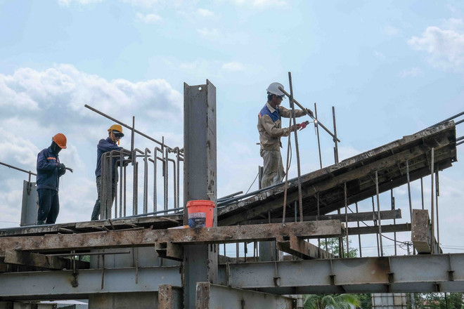 Công nhân thi công một hạng mục cầu trên dự án Đường vành đai phía Tây Cần Thơ. (Ảnh: Thanh Liêm/TTXVN) ttxvn_vanh dai phia tay (1).jpg