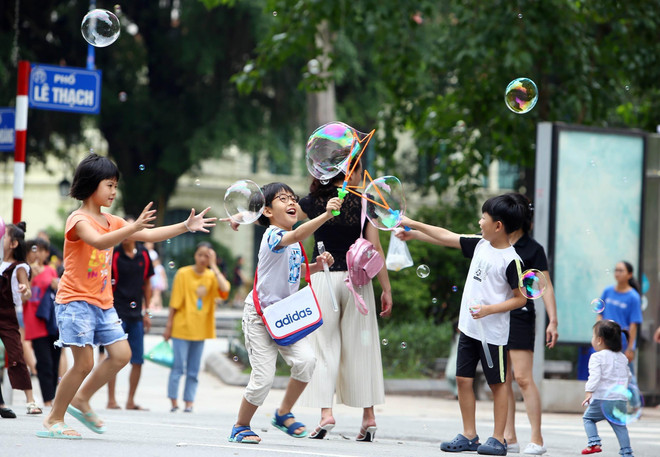 Các em nhỏ vui chơi tại phố đi bộ khu vực Hồ Hoàn Kiếm. (Ảnh: Danh Lam/TTXVN) Hà Nội: Hoàn chỉnh phương án mở rộng không gian đi bộ ở phố cổ ảnh 1