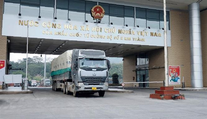 Xe chở hàng hóa thông quan tại cửa khẩu quốc tế đường bộ số II Kim Thành, Lào Cai. (Ảnh: Quốc Khánh/TTXVN) Thanh long được phép xuất khẩu trở lại qua cửa khẩu Lào Cai ảnh 1