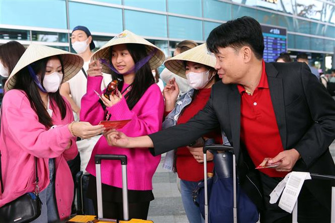 Ban tổ chức tặng lì xì cho những du khách quốc tế "xông đất" Đà Nẵng đầu năm mới Quý Mão bằng đường hàng không. (Ảnh: Trần Lê Lâm/TTXVN) Tàu biển, đám cưới Ấn Độ báo hiệu khởi sắc cho du lịch Đà Nẵng ảnh 2