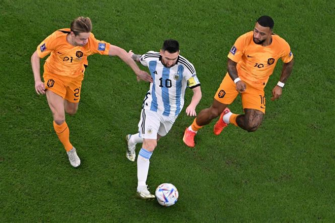 Tiền đạo Argentina Lionel Messi (giữa) đi bóng trước sự bám đuổi của các tuyển thủ Hà Lan trong trận tứ kết World Cup 2022 thứ hai ngày 9/12. (Ảnh: AFP/TTXVN) World Cup 2022: Những ứng cử viên cho danh hiệu Quả bóng vàng ảnh 1