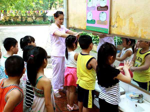 Hướng dẫn trẻ rửa tay bằng xà phòng. (Ảnh: Dương Ngọc/TTXVN) Hà Nội: Chủ động, quyết liệt phòng chống dịch bệnh mùa Hè ảnh 1