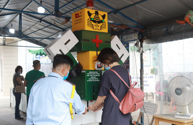 Đo thân nhiệt, rửa tay bằng robot tự động tại Bệnh viện Thống Nhất Thành phố Hồ Chí Minh. (Ảnh: Đinh Hằng/TTXVN) TP.HCM: Siết chặt công tác giám sát phòng dịch tại các bệnh viện ảnh 2