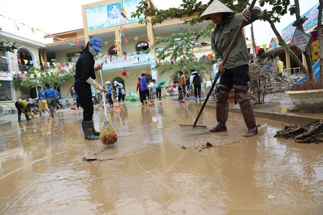 Vệ sinh sau mưa lũ. (Nguồn ảnh: TTXVN) Lãnh đạo Tổng cục Môi trường: 'Nỗi lo sau lũ là ô nhiễm môi trường' ảnh 1