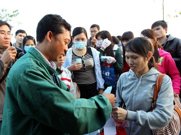 Phát vé cho công nhân ở TP.HCM về quê ăn Tết. (Ảnh: Thanh Vũ/TTXVN) TP.HCM: Tặng quà Tết gia đình công nhân bị mất việc ảnh 1