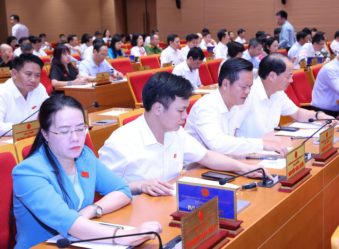 Đại biểu biểu quyết về việc tán thành chủ trương sắp xếp đơn vị hành chính cấp huyện, cấp xã giai đoạn 2023-2025 của thành phố Hà Nội. (Ảnh: Văn Điệp/TTXVN) TTXVN_1505Hoidongnhandan2.jpg