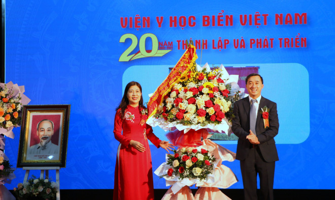 Phó Giáo sư, Tiến sỹ Trần Thị Quỳnh Chi, Viện trưởng Viện Y học Biển Việt Nam đón nhận lẵng hoa chúc mừng của Chủ tịch nước Nguyễn Xuân Phúc. (Ảnh: Minh Thu/TTXVN) Phát huy vị trí tuyến đầu chăm sóc sức khỏe nhân dân vùng biển đảo ảnh 1