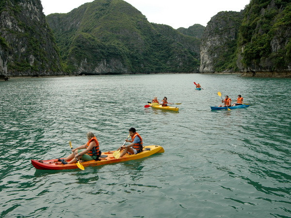 Du khách bơi thuyền Kayak trên Vịnh Hạ Long. (Ảnh: Tiến Dũng/TTXVN) Cho phép dịch vụ chèo thuyền kayak hoạt động trở lại trên vịnh Hạ Long ảnh 1