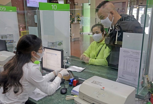 Khách hàng giao dịch tại hội sở chính Vietcombank, 198 Trần Quang Khải, Hà Nội. (Ảnh: Trần Việt/TTXVN) Kinh doanh bảo hiểm: Miếng bánh 'béo bở' của các ngân hàng ảnh 2