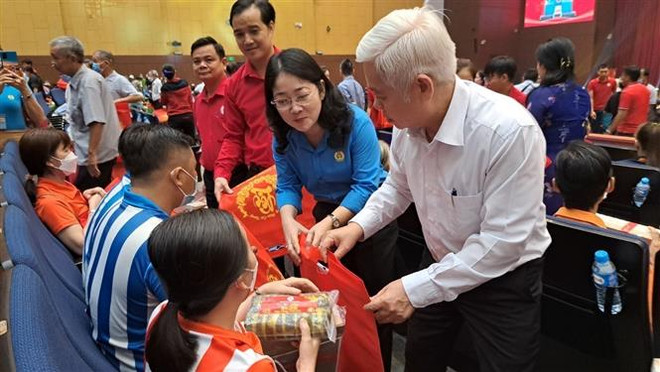 Lãnh đạo tỉnh Bình Dương tặng quà Tết cho người nghèo, người khuyết tật, công nhân lao động gặp khó khăn. (Ảnh: Huyền Trang/TTXVN) Chương trình Tết Nhân ái và Lễ hội Xuân hồng tại Bình Dương ảnh 1