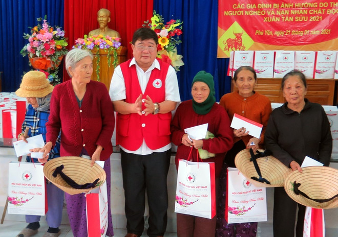 Đại diện Hội chữ thập đỏ tỉnh Phú Yên tặng quà cho các hộ dân bị ảnh hưởng thiên tai. (Ảnh: Xuân Triệu/TTXVN) 75 năm Hội Chữ thập đỏ Việt Nam: Vì mọi người - Ở mọi nơi ảnh 3