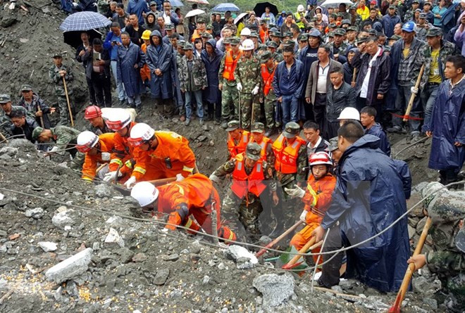 Nhân viên cứu hộ nỗ lực tìm kiếm người mất tích trong vụ lở đất. (Nguồn: EPA/TTXVN) Sự kiện quốc tế 19-25/6: Thủ lĩnh IS thực sự đã chết? ảnh 3