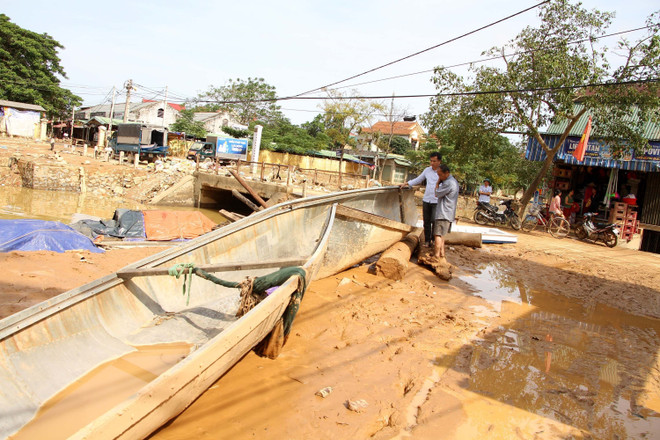 Ông Võ Văn Bình, thôn Đồng Tư, xã Hiền Ninh, huyện Quảng Ninh (Quảng Bình) bên chiếc thuyền của bị nước lũ đánh chìm. (Ảnh: Văn Tý/TTXVN) Người đàn ông gần 70 tuổi lao thuyền vào lũ dữ để cứu đồng bào ảnh 1