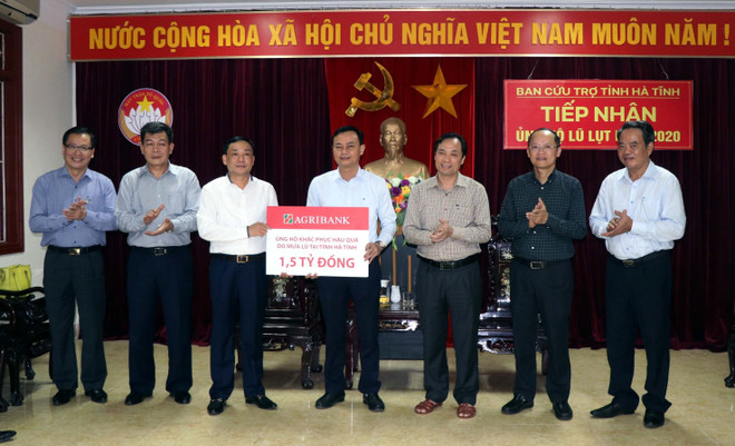 Doanh nghiệp khối cơ quan Trung ương Ngân hàng Nông nghiệp Việt Nam trao tiền ủng hộ cho Hà Tĩnh. (Ảnh: Công Tường/TTXVN) Đồng bào cả nước đồng hành cùng người dân vùng lũ Hà Tĩnh ảnh 1
