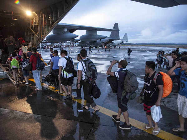 Những người sống sót sau bão Haiyan lên máy bay vận tải quân sự để rời khỏi thành phố Tacloban, đến Manila ngày 14/11. (Nguồn: AFP/TTXVN) Công dân Việt tại Philippines đều đã an toàn sau bão ảnh 1