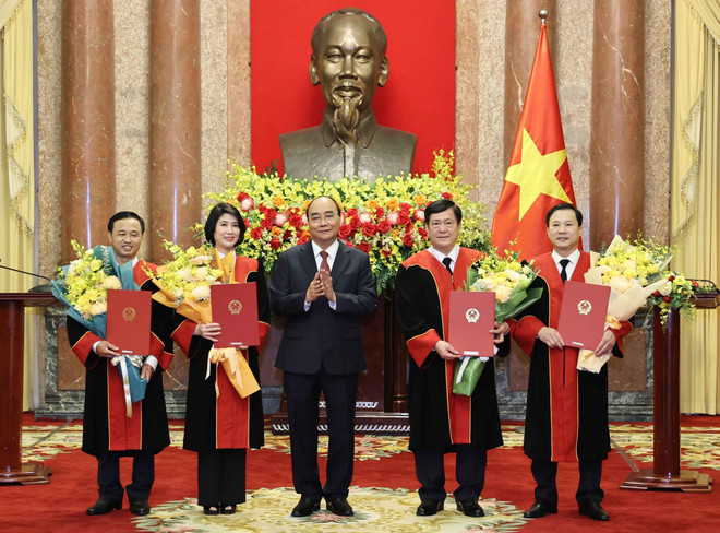 Chủ tịch nước Nguyễn Xuân Phúc trao quyết định và tặng hoa chúc mừng 4 thẩm phán Tòa án Nhân dân tối cao. (Ảnh: Thống Nhất/TTXVN) Chủ tịch nước trao quyết định bổ nhiệm thẩm phán TAND tối cao ảnh 1