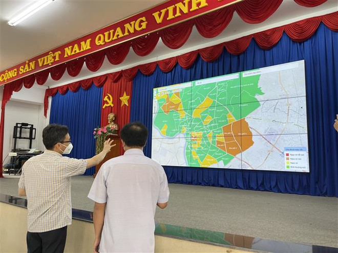Phó Thủ tướng Chính phủ Vũ Đức Đam xem bản đồ xanh của thành phố Thủ Dầu Một. (Ảnh: Huyền Trang/TTXVN) Bình Dương cần cân nhắc những loại hình thiết yếu sẽ được mở cửa ảnh 1