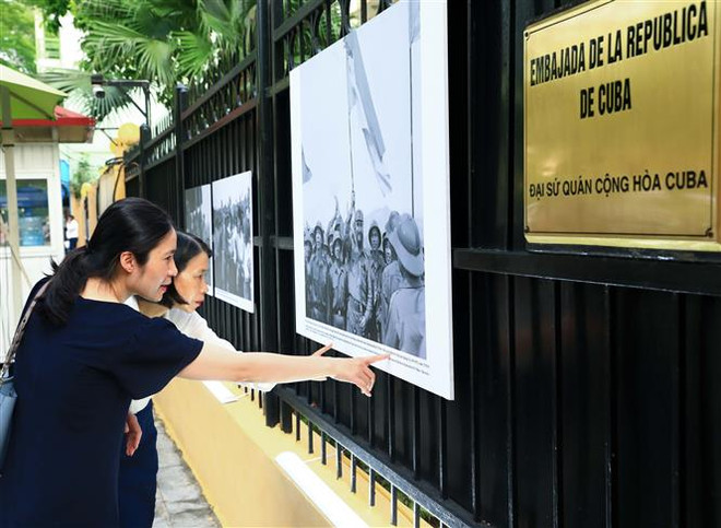 Khách tham quan triển lãm ảnh "Đại thắng Cuba và Việt Nam". (Ảnh: Hoàng Hiếu/TTXVN) Lễ Kỷ niệm 50 năm chuyến thăm đầu tiên tới Việt Nam của Lãnh tụ Fidel ảnh 4