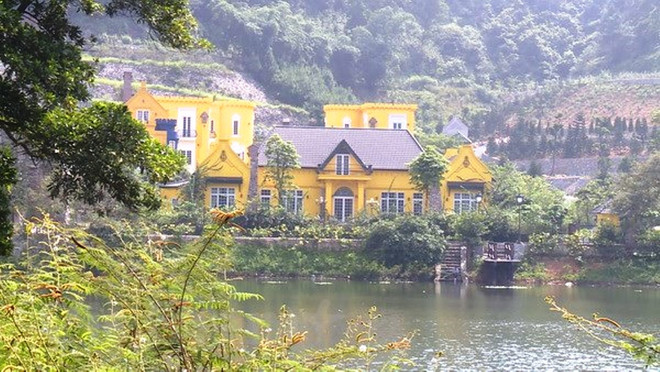 Công trình màu vàng xây dựng trên khu vực hồ Đồng Đò tại xã Minh Trí, huyện Sóc Sơn. (Ảnh Nguyễn Dũng/Vietnam+) Yêu cầu thanh tra toàn diện việc quản lý, sử dụng đất rừng Sóc Sơn ảnh 1