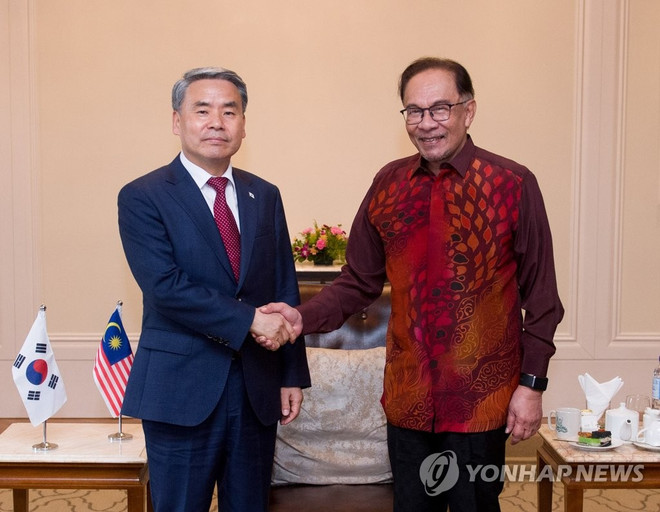 Bộ trưởng Quốc phòng Hàn Quốc Lee Jong-sup (trái) bắt tay Thủ tướng Malaysia Anwar Ibrahim trong cuộc gặp ở Langkawi, Malaysia ngày 24/5. (Nguồn: Yonhap) Malaysia-Hàn Quốc tăng cường hợp tác trong ngành vũ khí và quốc phòng ảnh 1