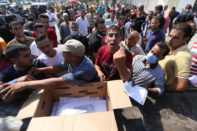 Người Palestine tập trung để xin giấy phép lao động của Israel, tại Khan Younis, phía nam Dải Gaza . (Nguồn: Reuters) Israel cấp thêm hàng nghìn giấy phép nhập cảnh cho người Palestine ảnh 1