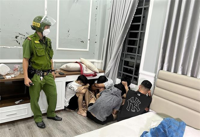 Các đối tượng bị bắt quả tang tụ tập sử dụng ma túy. (Ảnh: TTXVN) An Giang: Đột kích căn hộ, phát hiện 14 đối tượng đang "bay lắc" ảnh 1