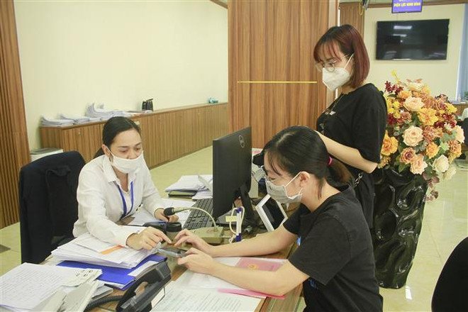 Cán bộ tại Trung tâm hành chính công tỉnh Ninh Bình hướng dẫn người dân sử dụng các dịch vụ công trực tuyến. (Ảnh minh họa: Hải Yến/TTXVN) Nhiều thủ tục hành chính dịch vụ công chưa xong tái cấu trúc quy trình ảnh 1