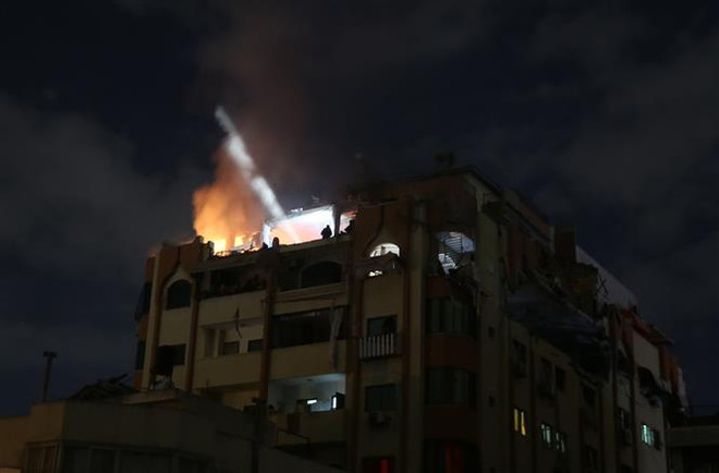Một tòa nhà bốc cháy sau cuộc không kích của Israel tại Dải Gaza ngày 9/5. (Ảnh: AA/TTXVN) Isarel tấn công vị trí quân sự của Hamas tại Dải Gaza ảnh 1