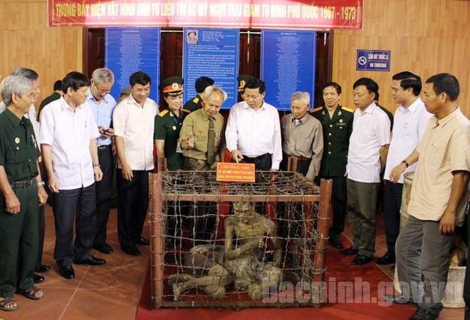 Lãnh đạo tỉnh Bắc Ninh tham quan hiện vật trại giam Phú Quốc tại Hội thảo khoa học về thành tích của liệt sỹ Nguyễn Đình Xô. (Nguồn: Bacninh.gov.vn) Truy tặng danh hiệu Anh hùng LLVTND cho liệt sỹ Nguyễn Đình Xô ảnh 1