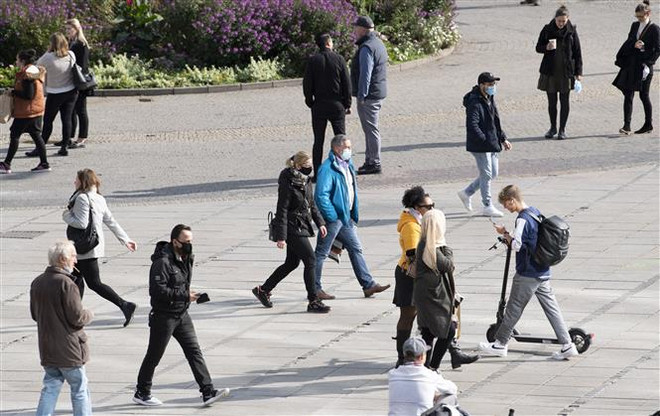 Người dân đeo khẩu trang phòng dịch COVID-19 tại Stuttgart, Đức ngày 13/10/2020. (Ảnh: AFP/TTXVN) Đại dịch COVID-19 có thể sẽ tái lập trật tự kinh tế thế giới ảnh 2