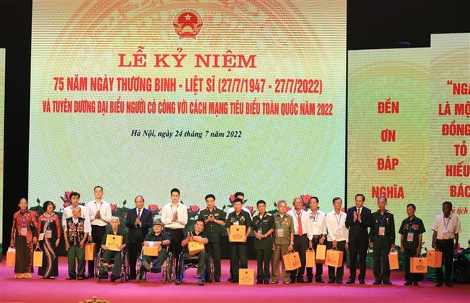 Chủ tịch nước Nguyễn Xuân Phúc và Đại tướng Phan Văn Giang, Bộ trưởng Bộ Quốc phòng tặng quà cho các đại biểu Người có công với cách mạng toàn quốc năm 2022. (Ảnh: Tuấn Anh/TTXVN) "Mãi mãi biết ơn những người mang lại độc lập, hòa bình cho Tổ quốc" ảnh 2