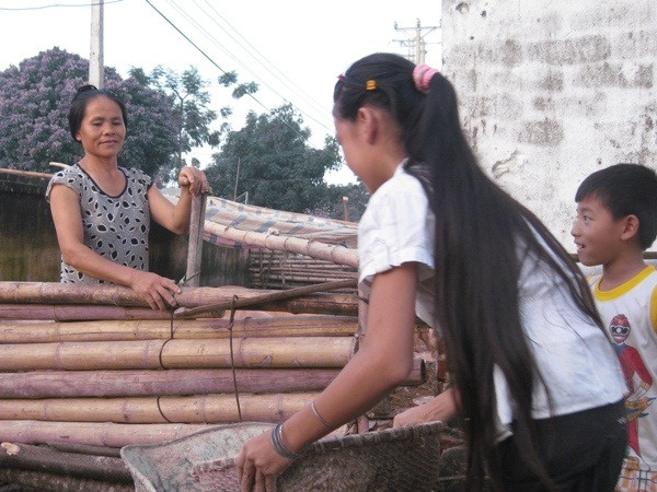 Người dân vùng rốn lũ xã Hòa Hải dọn dẹp đón xuân về. (Ảnh: Hùng Võ/Vietnam+) Vùng "rốn lũ" miền Trung tạm quên khó rạo rực đón xuân ảnh 1