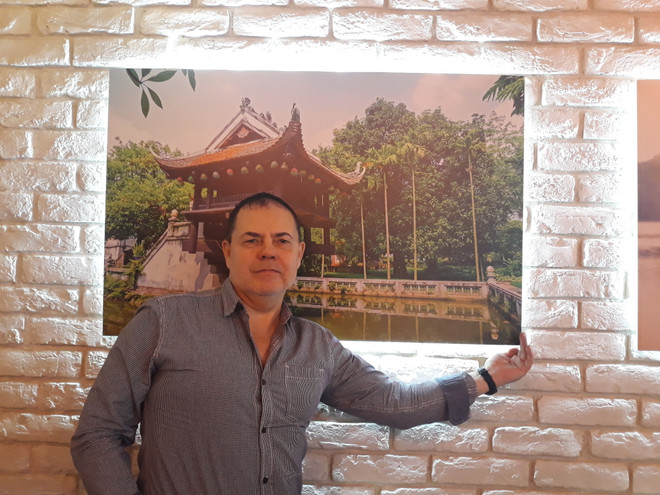 Chuyên gia Grigory Trofimchuk bên bức ảnh chùa Một Cột được treo tại một nhà hàng Việt Nam ở Moskva (Ảnh: Hồng Quân) Chuyên gia Nga đánh giá cao đóng góp to lớn của Việt Nam đối với ASEAN ảnh 1