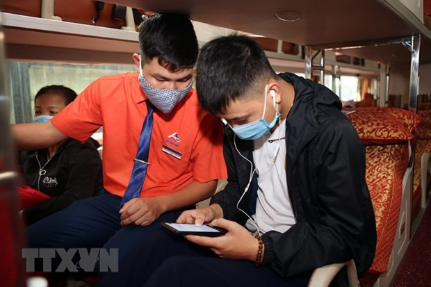 Hành khách tại bến xe Nước Ngầm (Hà Nội), được nhân viên nhà xe hướng dẫn khai báo y tế trên ứng dụng điện thoại. (Ảnh: Danh Lam/TTXVN) Xử lý nghiêm vi phạm phòng chống dịch COVID-19 và nồng độ cồn ảnh 1