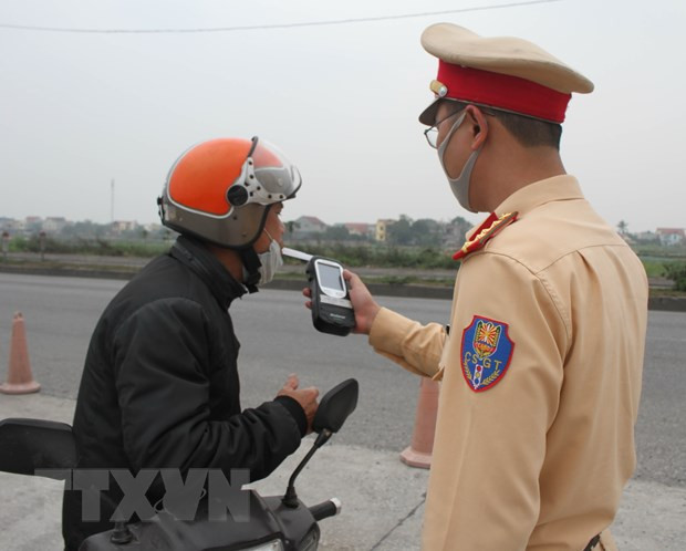 Cảnh sát giao thông kiểm tra nồng độ cồn của người điều khiển phương tiện. (Ảnh: Thùy Dung/TTXVN) Xử lý nghiêm vi phạm phòng chống dịch COVID-19 và nồng độ cồn ảnh 3
